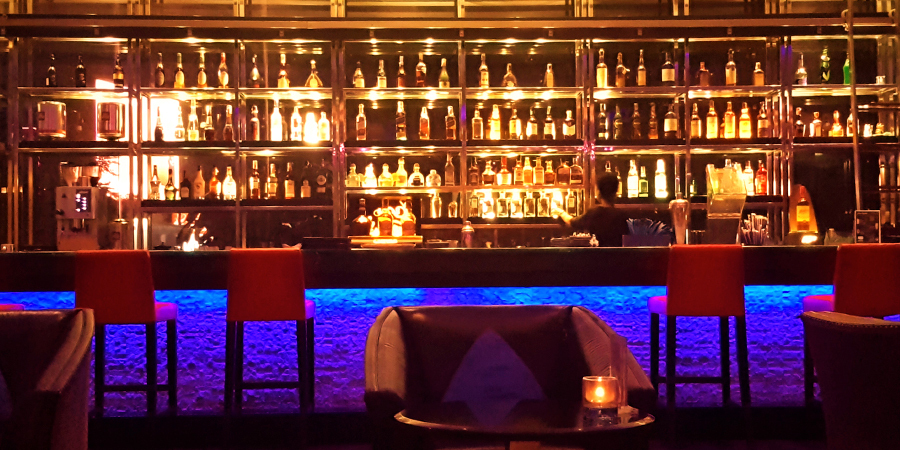 bar counter illuminated by white light for Bartenders and with soft blue accents for customers