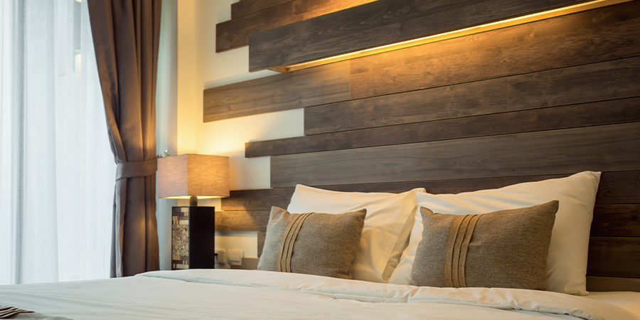 Modern bedroom design with warm linear lighting on the headboard