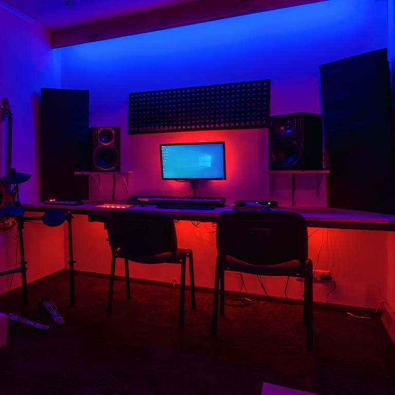 gamer room illuminated with blue LED light and red RGB lights under the table