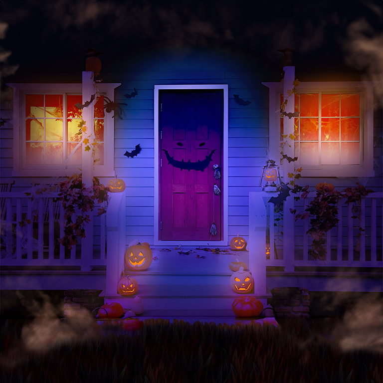 A foggy front door entrance for a home, decorated with LED jack-o’-lanterns, bat cutouts, and indoor orange lighting.