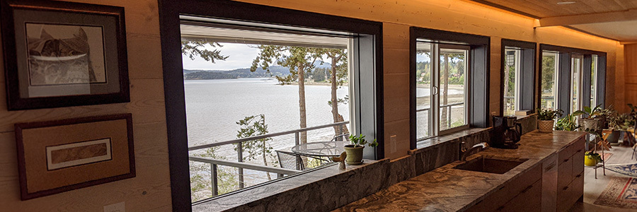Kitchen with Large Windows and Warm Cove Lighting Kitchen interior with panoramic water views and ambient ceiling lighting