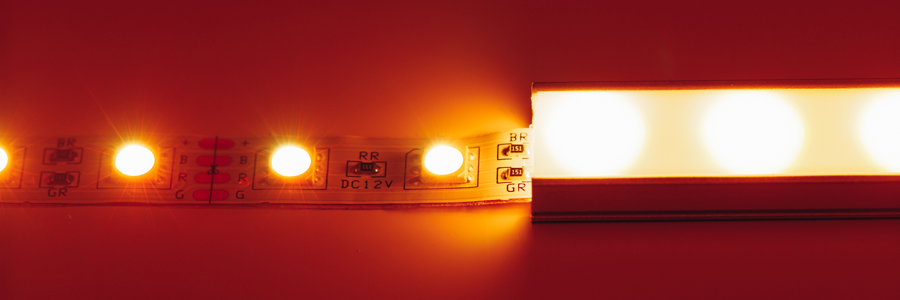  Close-up of an LED strip light with a diffuser cover, emitting warm orange light