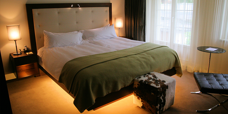 Modern Bedroom Featuring Under-Bed Lighting Cozy bedroom with under-bed lighting and large headboard