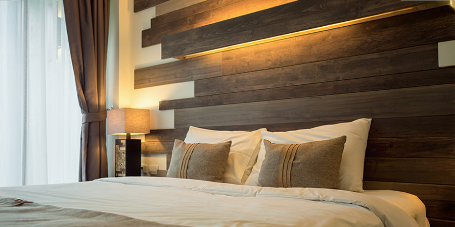 Cozy bedroom featuring a wooden headboard, soft pillows, and warm lighting