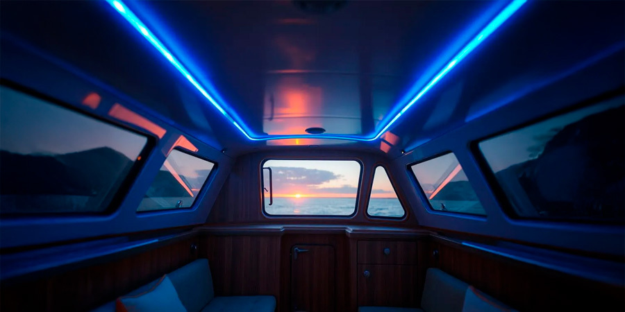 A modern boat interior with panoramic windows, comfortable seating, and ambient LED lighting creating a relaxing atmosphere