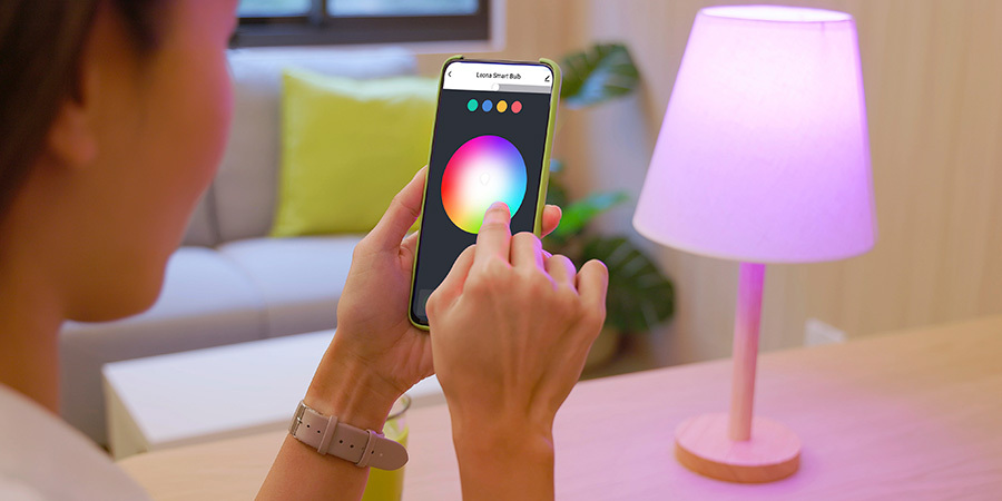 Adjusting the color of a lamp using a smart lighting app on a smartphone