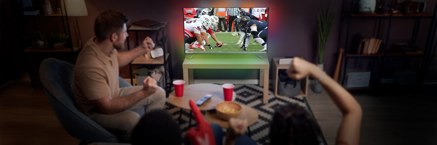 Group of friends watching a football game on a large flat-screen television, complemented by LED backlighting and minimalist furniture.